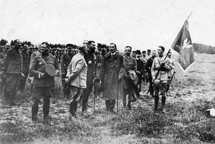 Uroczystość wręczenia sztandaru 1 pułkowi strzelców pieszych. W płaszczu stoi Roman Dmowski. 18 czerwca 1918 r. Źródło: CAW