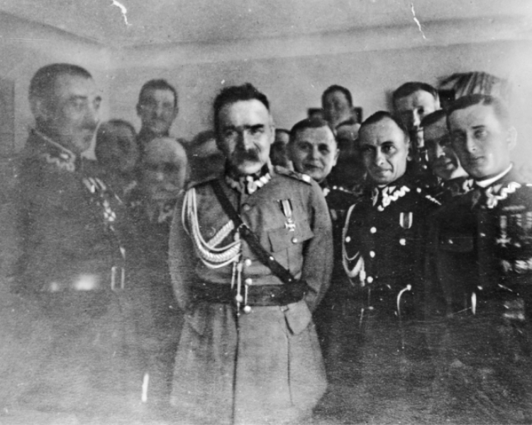 Marszałek Józef Piłsudski z oficerami. 1. z lewej stoi płk Zygmunt Piasecki (1. z lewej). Na piersi marszałka widoczny krzyż Virtuti Militari. Źródło: NAC